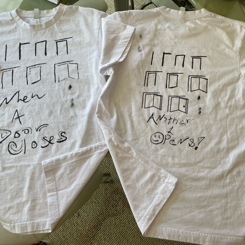 “When a door closes, another opens” white quality tee